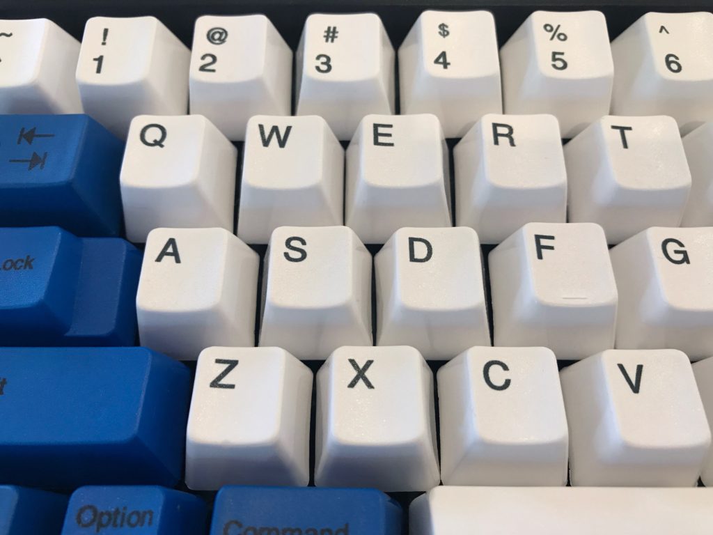 Spacesaver M dye sublimated PBT keycaps in brilliant white with blue ANSI key mod